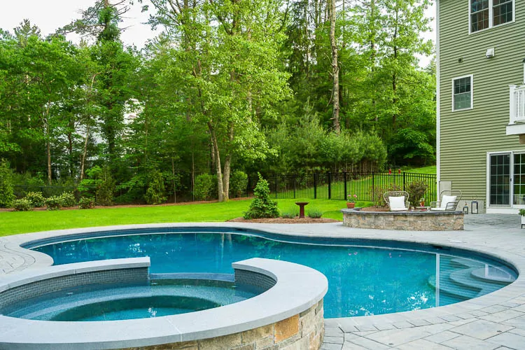 Gunite pool with attached spa and stone surround